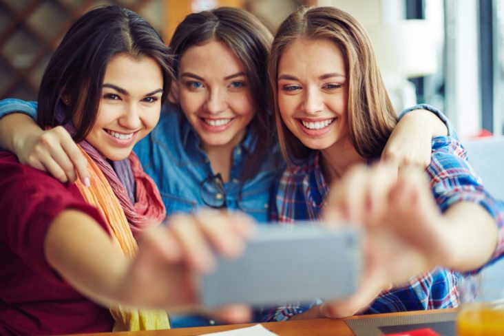 A group of teenage girls smile for a selfie